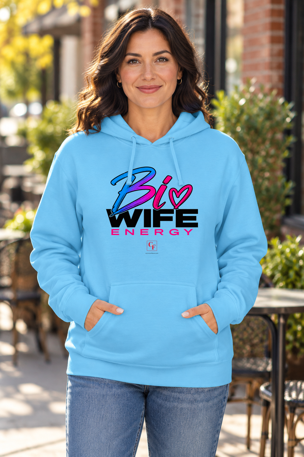 Woman wearing the Sky blue Bi Wife Energy hoodie outside a café