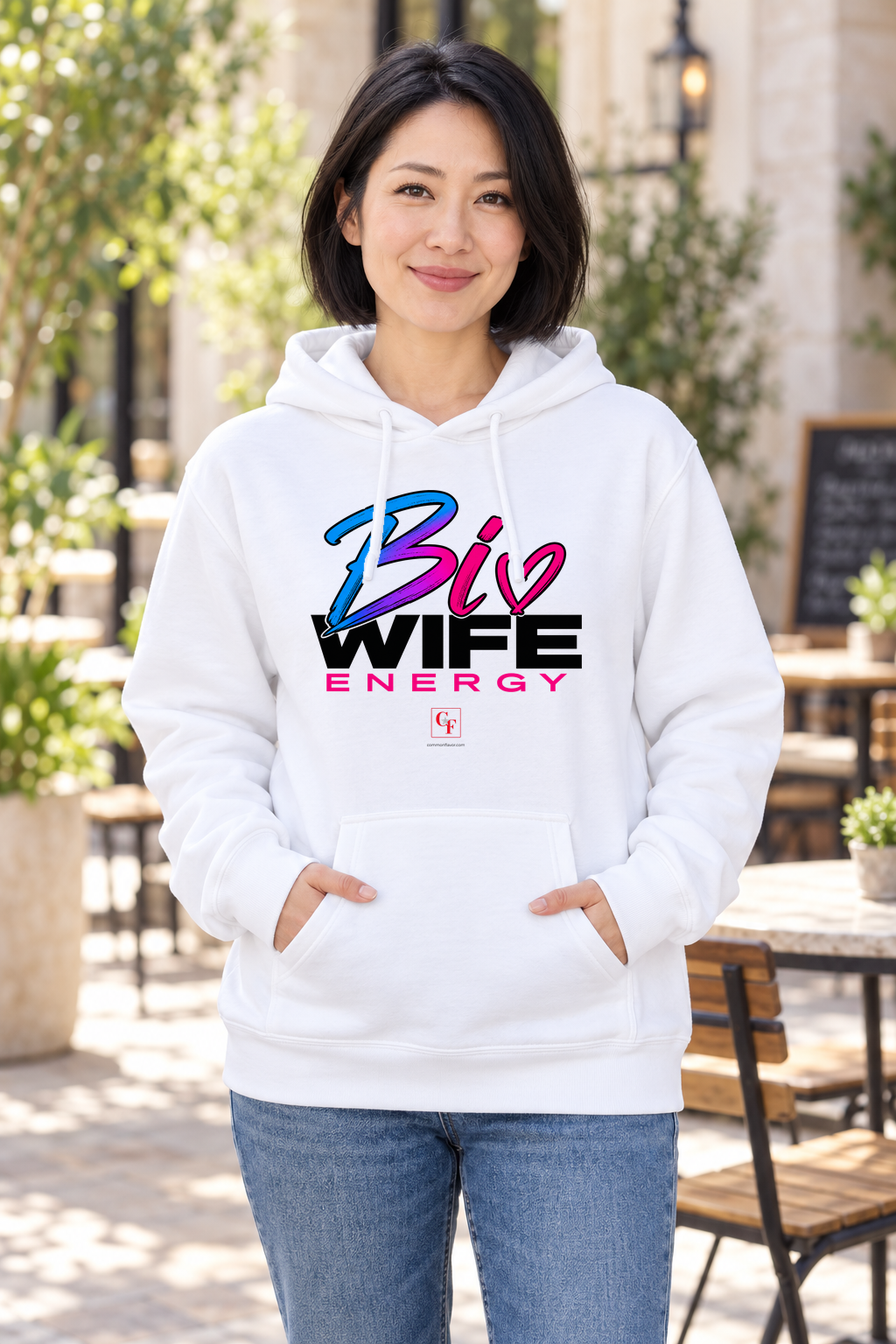 Woman wearing the White Bi Wife Energy hoodie in an outdoor lifestyle setting