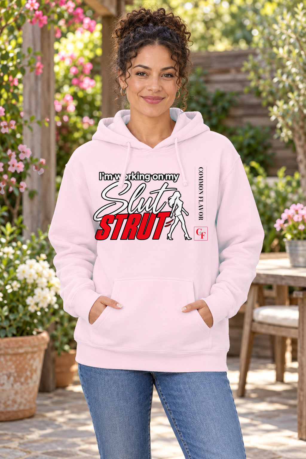 Slut Strut Variation Hoodie in Light Pink on a model outdoors — Common Flavor